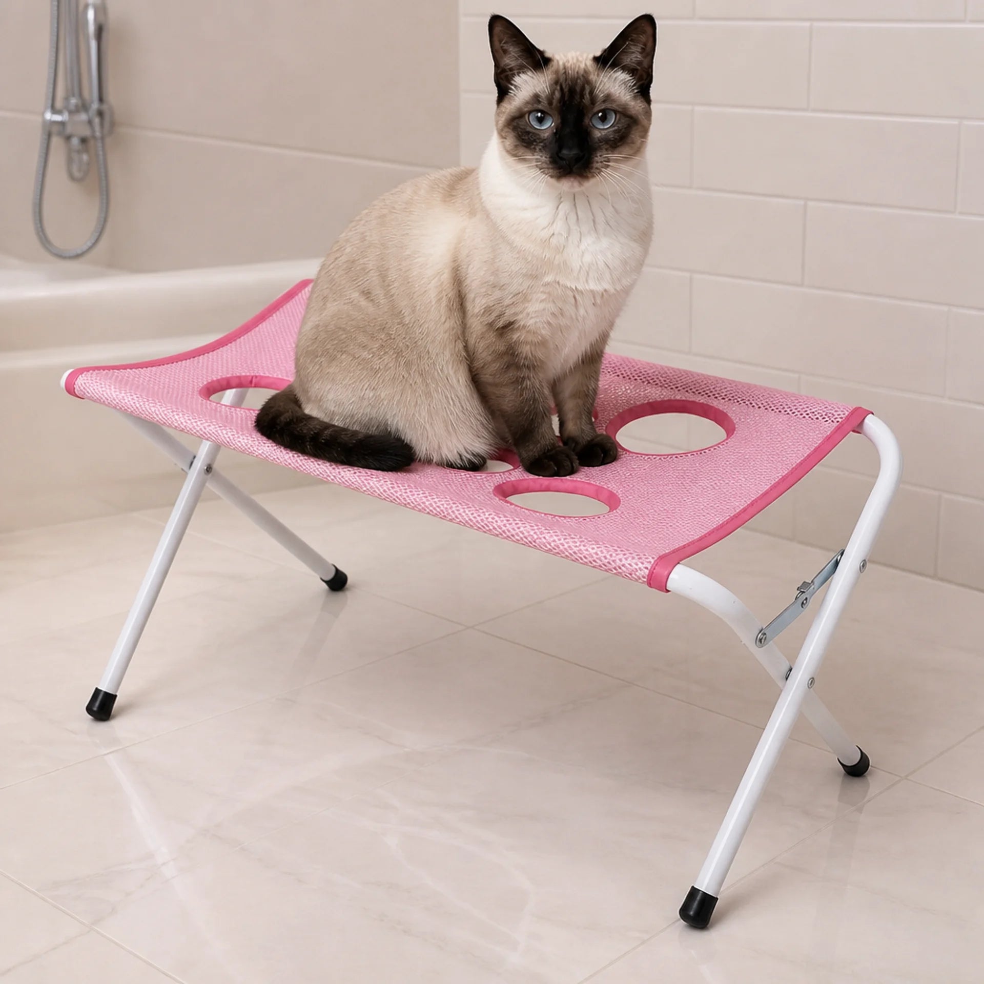 Pink Purrenza Grooming Stand set up in a bright bathroom with a Siamese cat sitting calmly on it